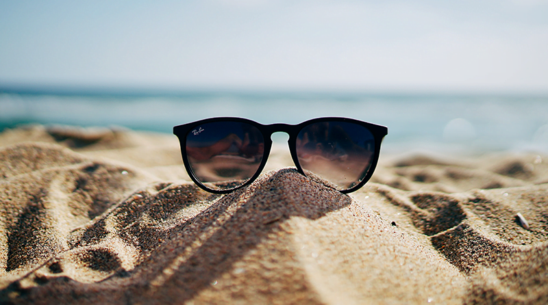 A pair of sunglasses sitting on the beach, representing detection efficacy in the summer heat.