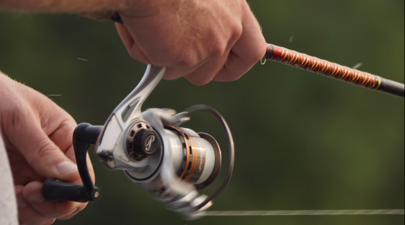 A man holding a fishing reel, representing the shift from threat hunting to threat catching.