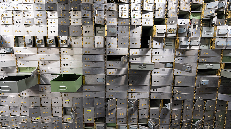 Rows of safety deposit boxes with doors open representing FinTech api security