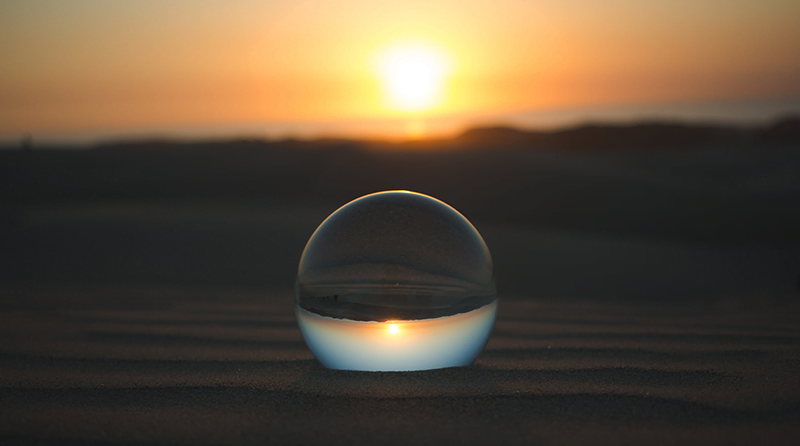 A sunset and a gazing ball with a reflection representing predictions and api security bots