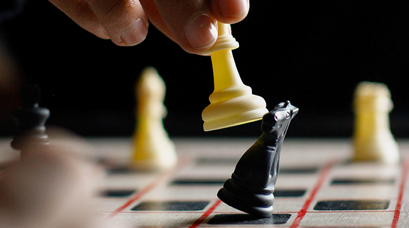 A chess board with a pawn taking out a knight representing shopping bots