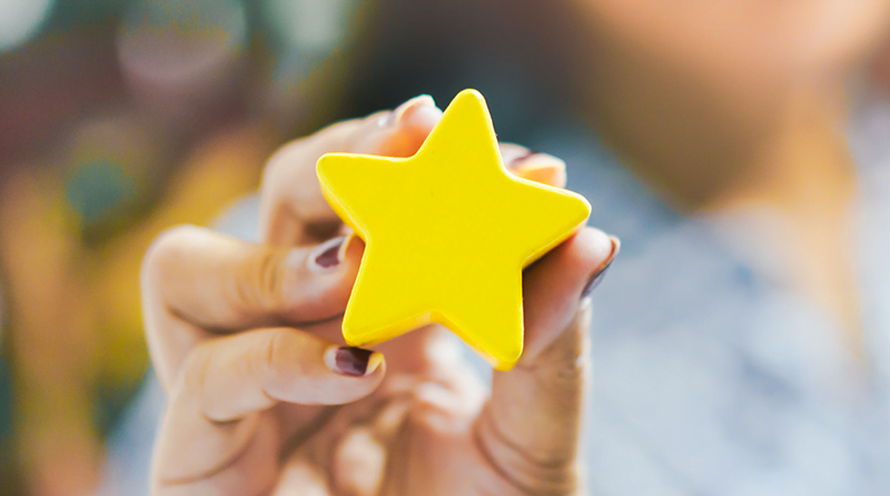 Woman holding a gold star representing application security award