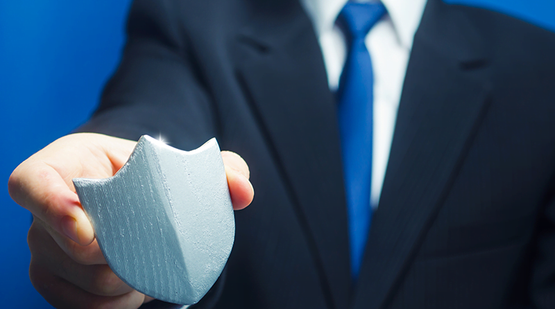 Man in a business suite holding a silver shield representing shield right shift left api security