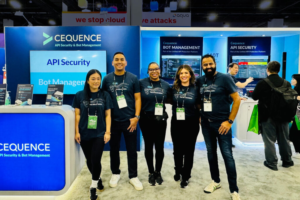 A photo of the Cequence booth staff in front of the futuristic-looking Cequence trade show booth at the Black Hat 2024 conference.