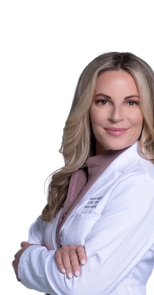 Smiling woman with blonde hair wearing a white lab coat and mauve shirt, arms crossed.