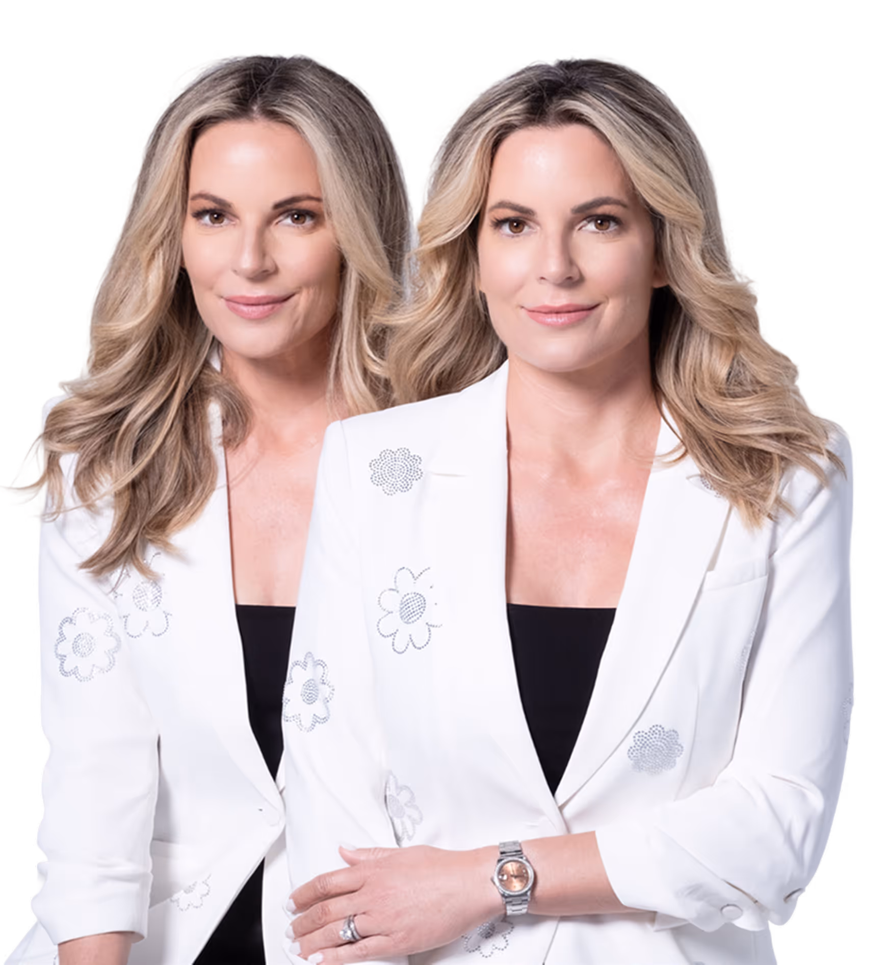 Two blonde women wearing white blazers with floral designs, smiling and posing side by side.