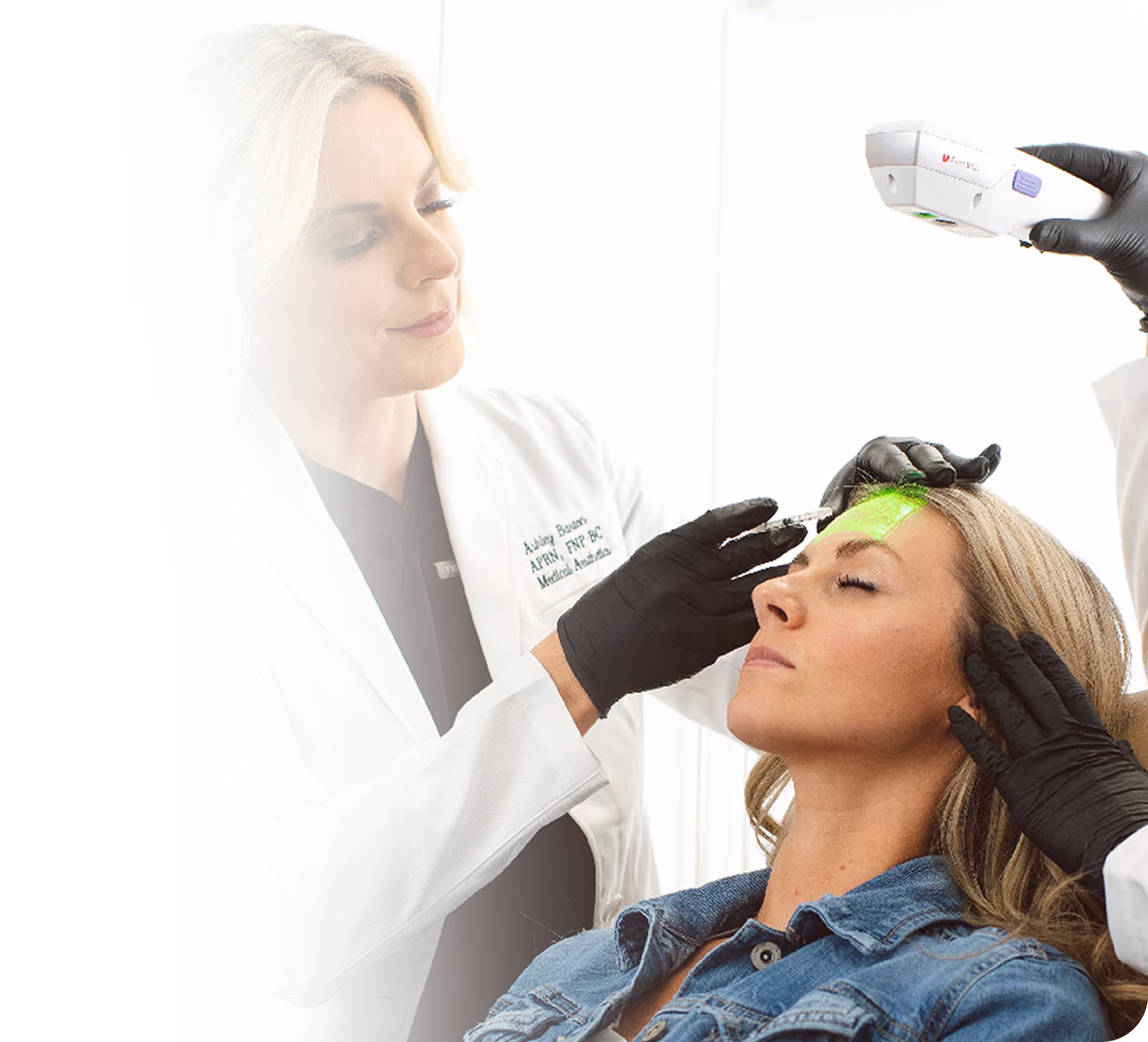 Medical professional in white coat and gloves treating a woman's forehead with a laser device.