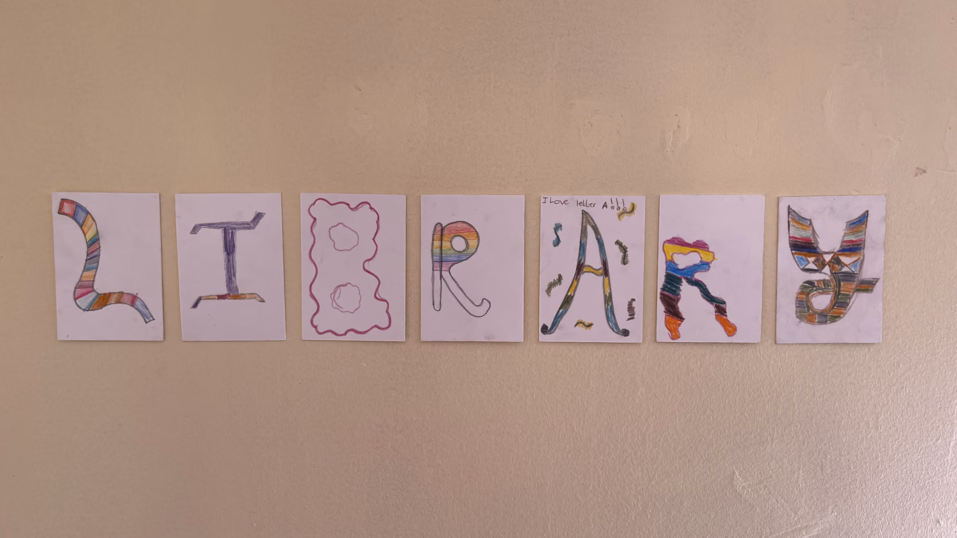Bunte Zeichnungen von Buchstaben, die das Wort LITRARY an einer Wand bilden.