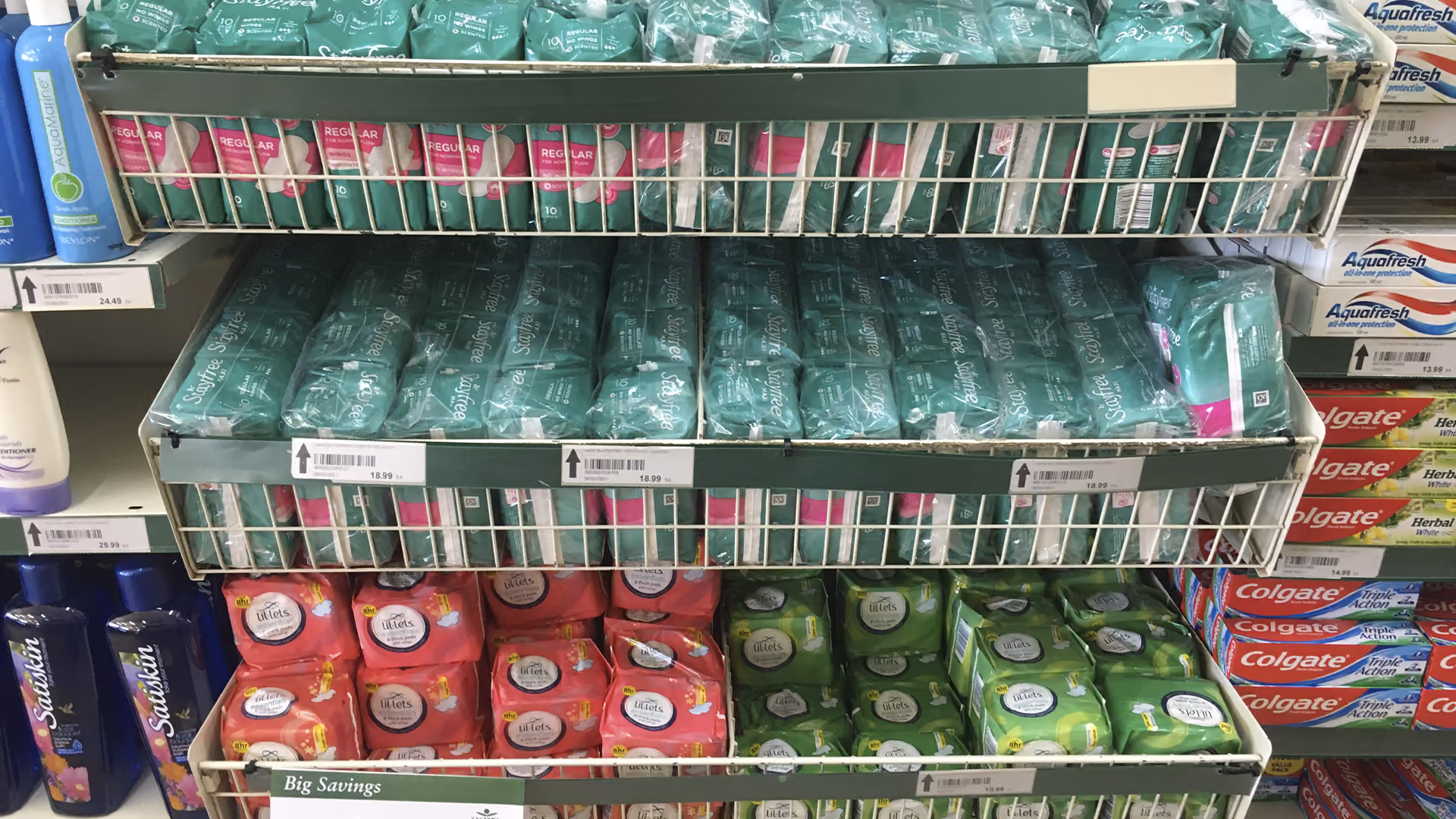 Regal mit Hygieneprodukten wie Damenbinden und Zahnpasta verschiedener Marken im Geschäft.