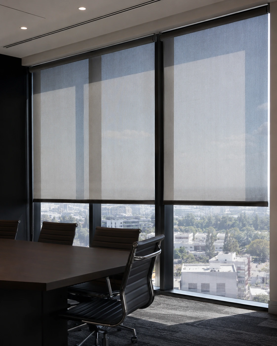 Charcoal roller shades on the floor-to-ceiling windows of a boardroom
