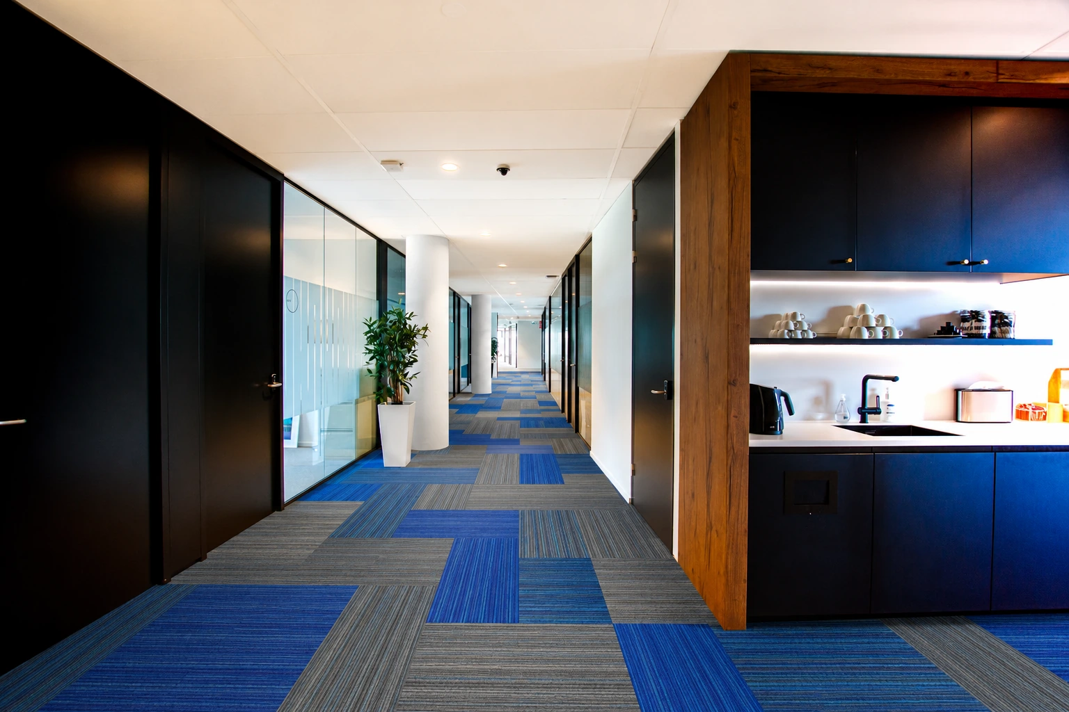 Blue and grey carpet tile planks along an office corridor
