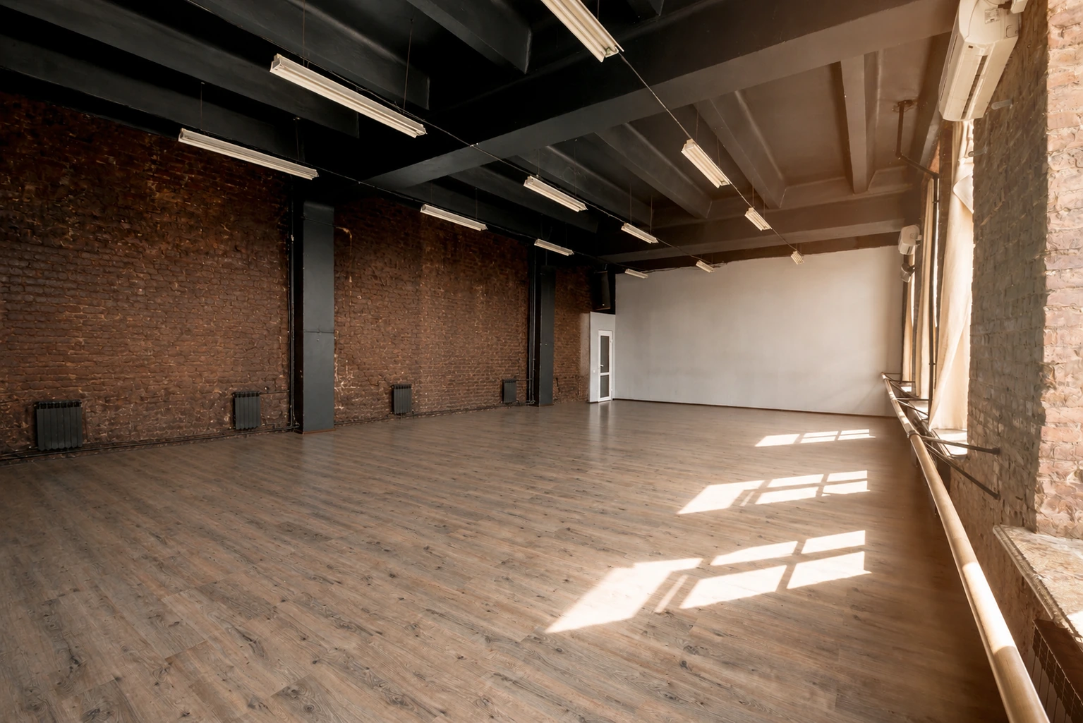 Wood-look commercial vinyl flooring in a loft with brick walls and exposed beams