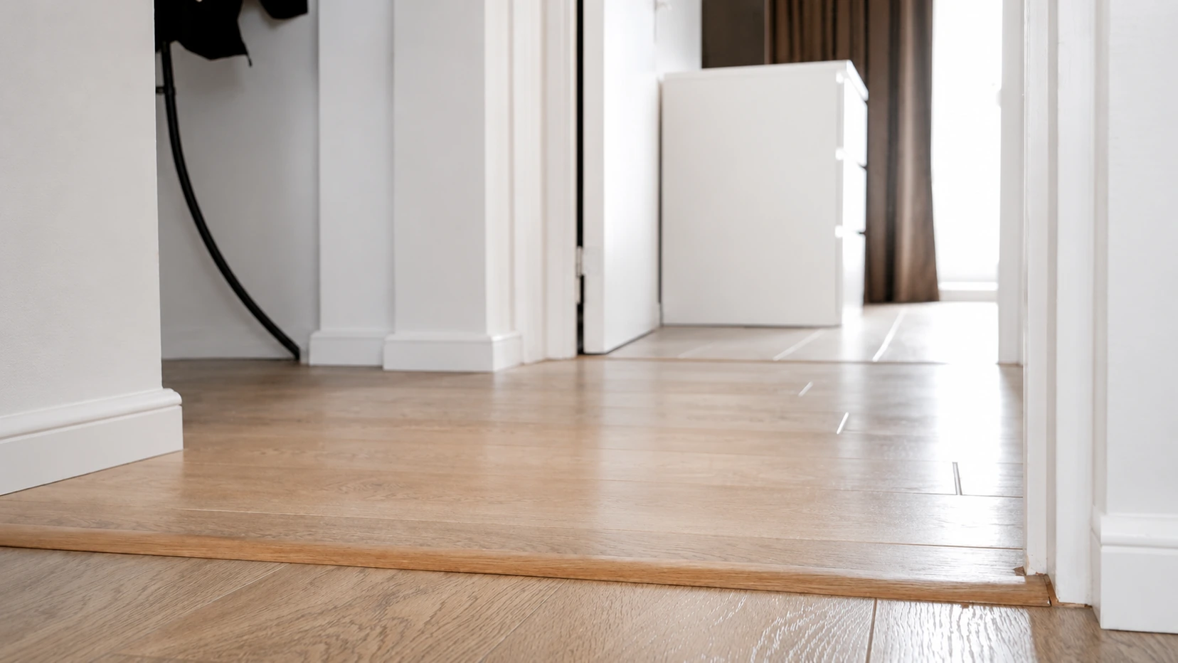 Wood transition strip across a doorway between two rooms