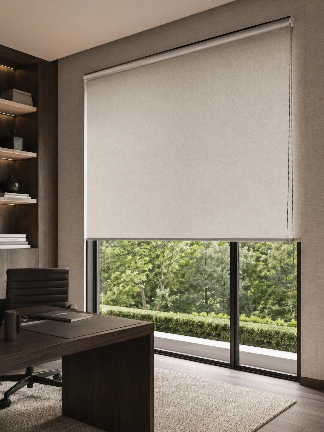 Manual roller shade over a wide window in a dark study