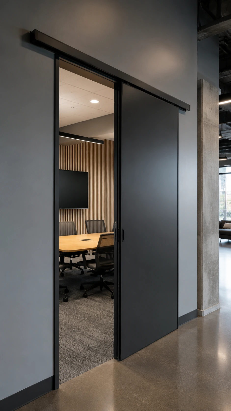 Dark sliding door on a ceiling track between two rooms