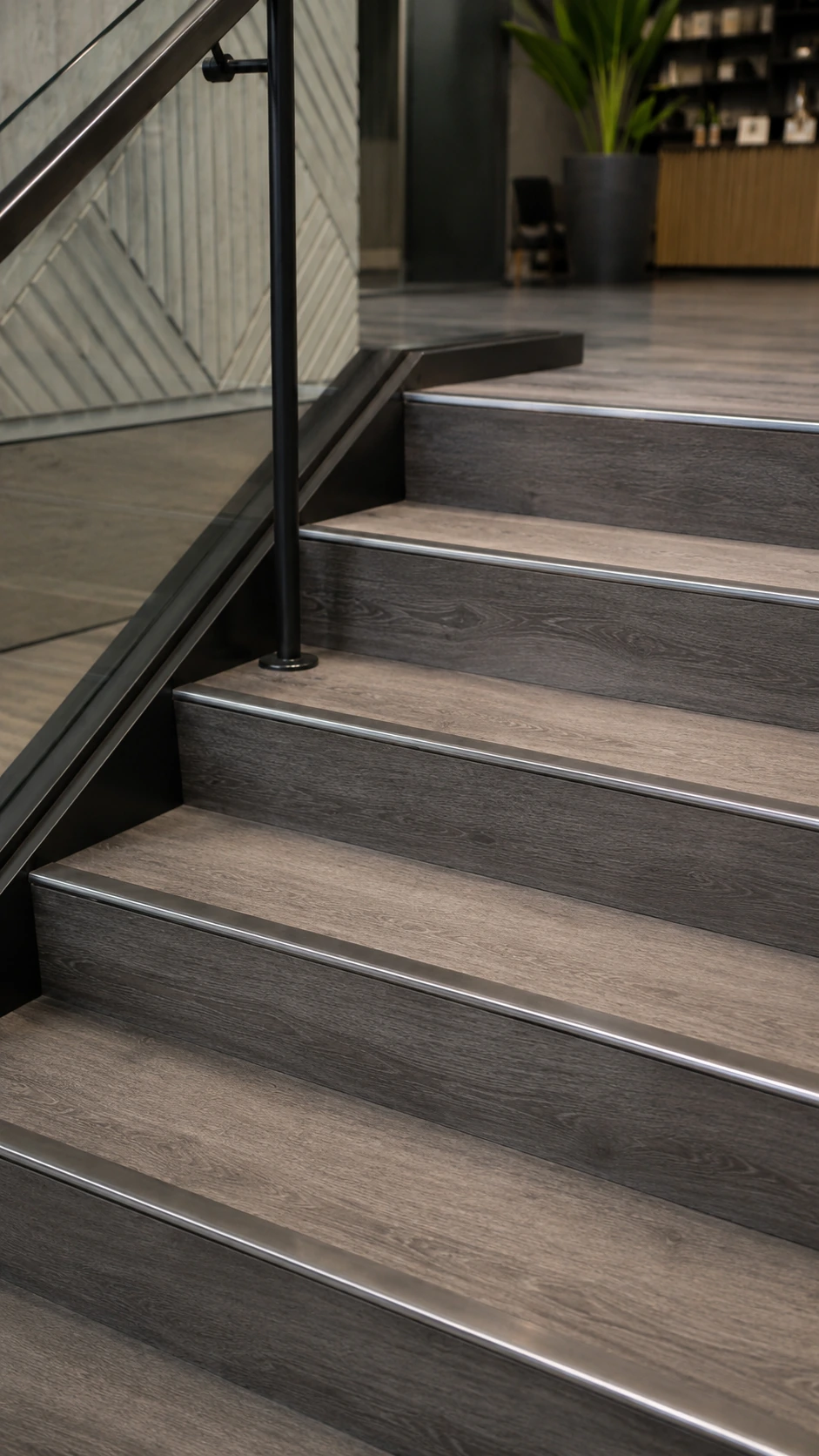 Grey stair nosing on a staircase with a black railing