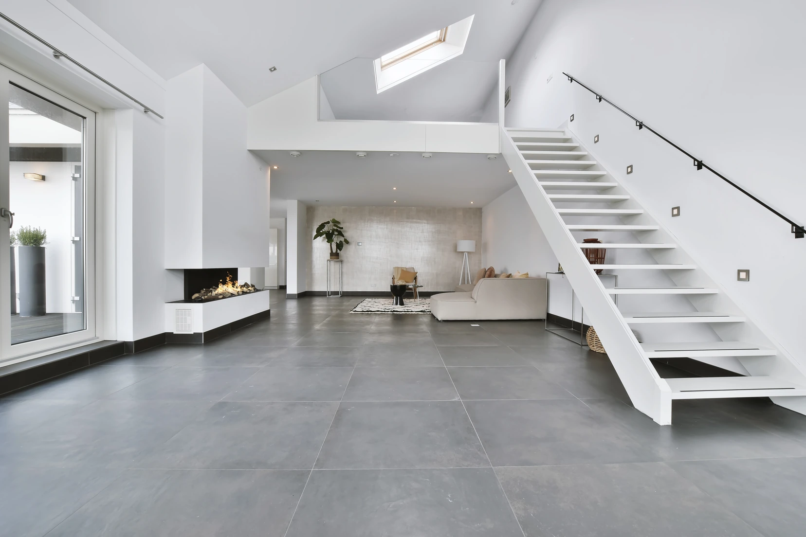 Grey stone-look vinyl flooring in an open living space with a staircase