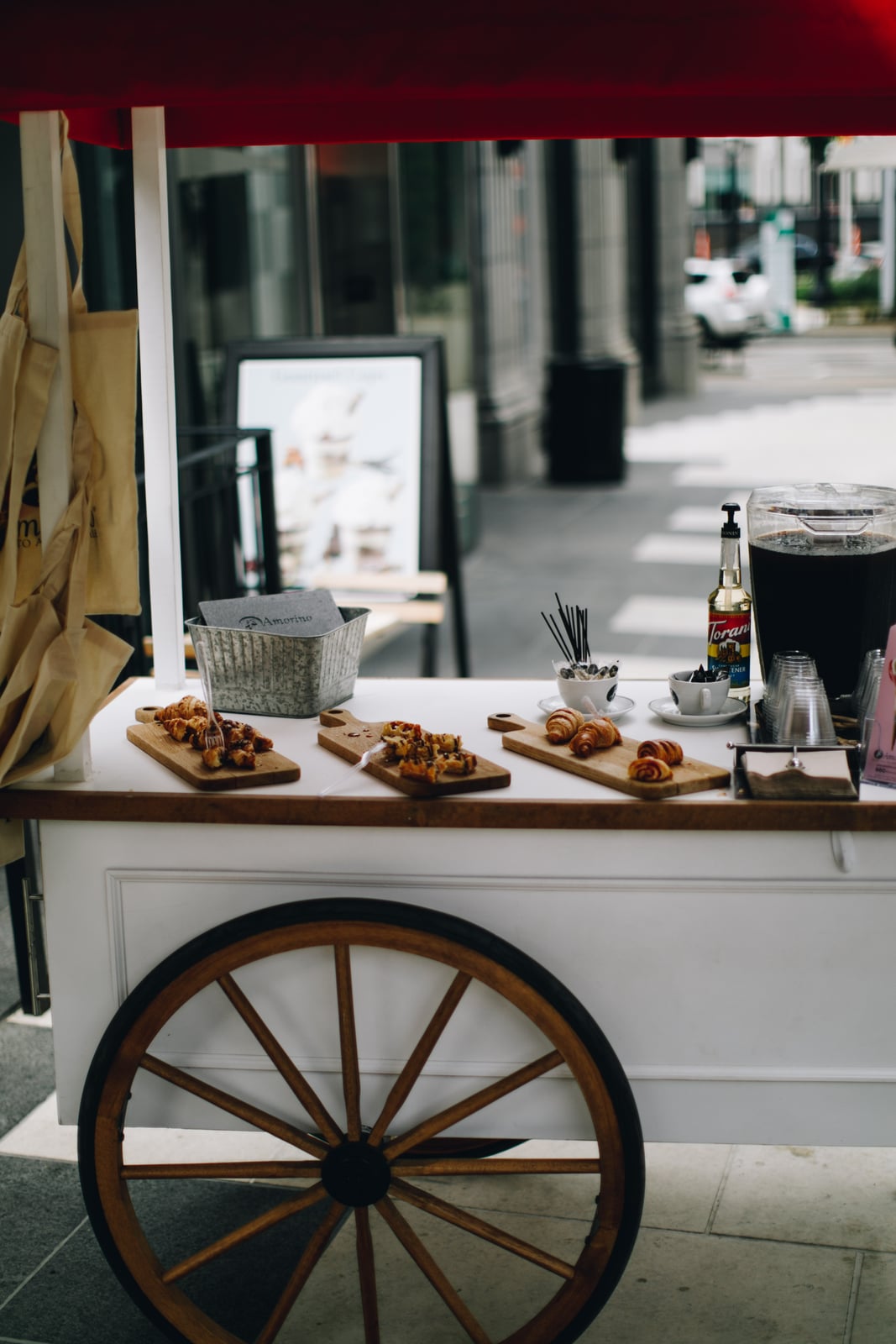 Chariot à pâtisseries crème, avec une roue en bois et un auvent rouge
