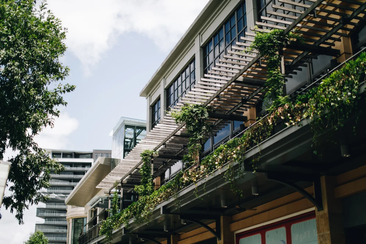 Detalles de madera y balcones con vegetación en Buckhead Village