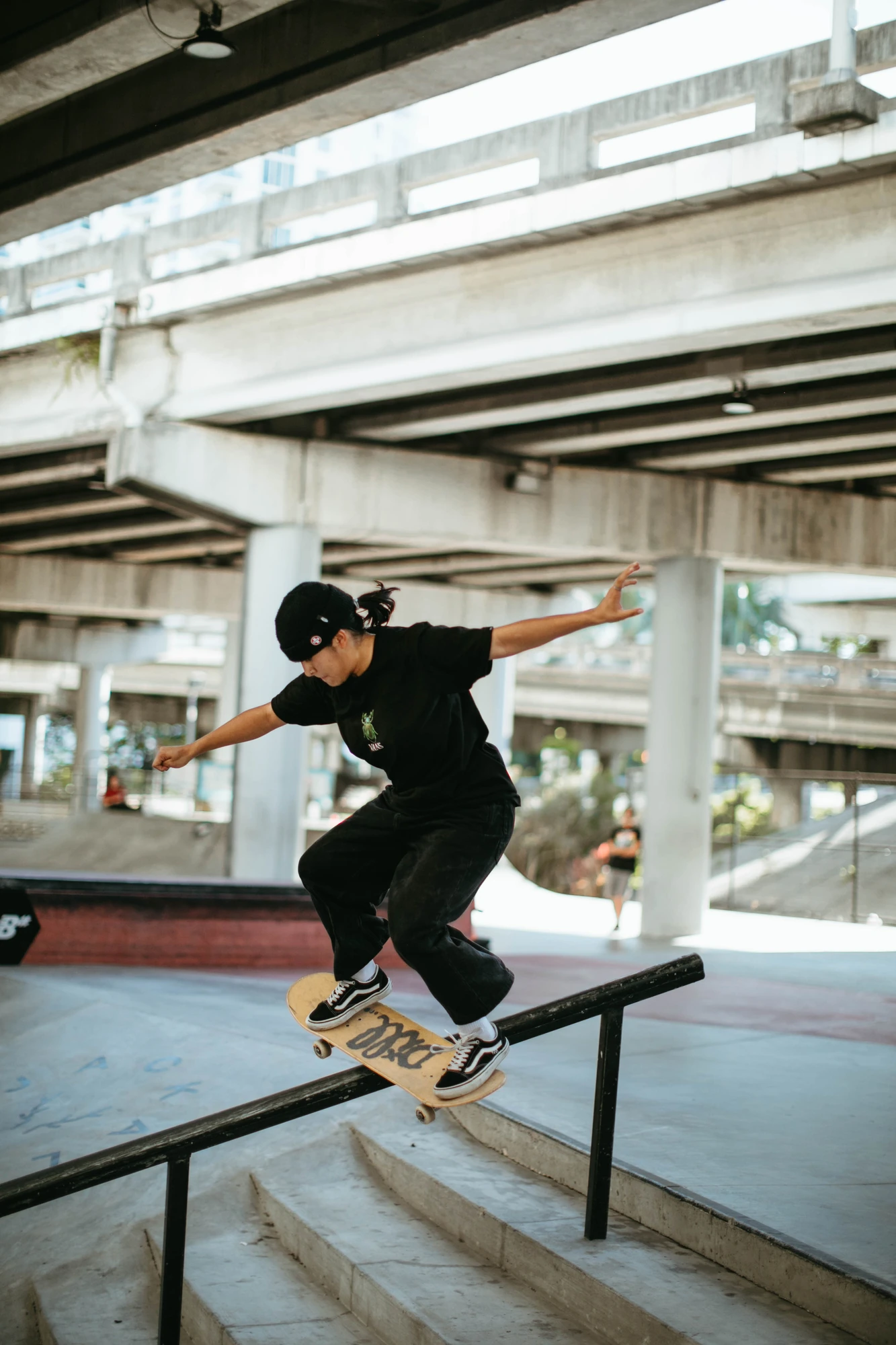 Un skateur en équilibre sur une barre sous une structure en béton à Miami.