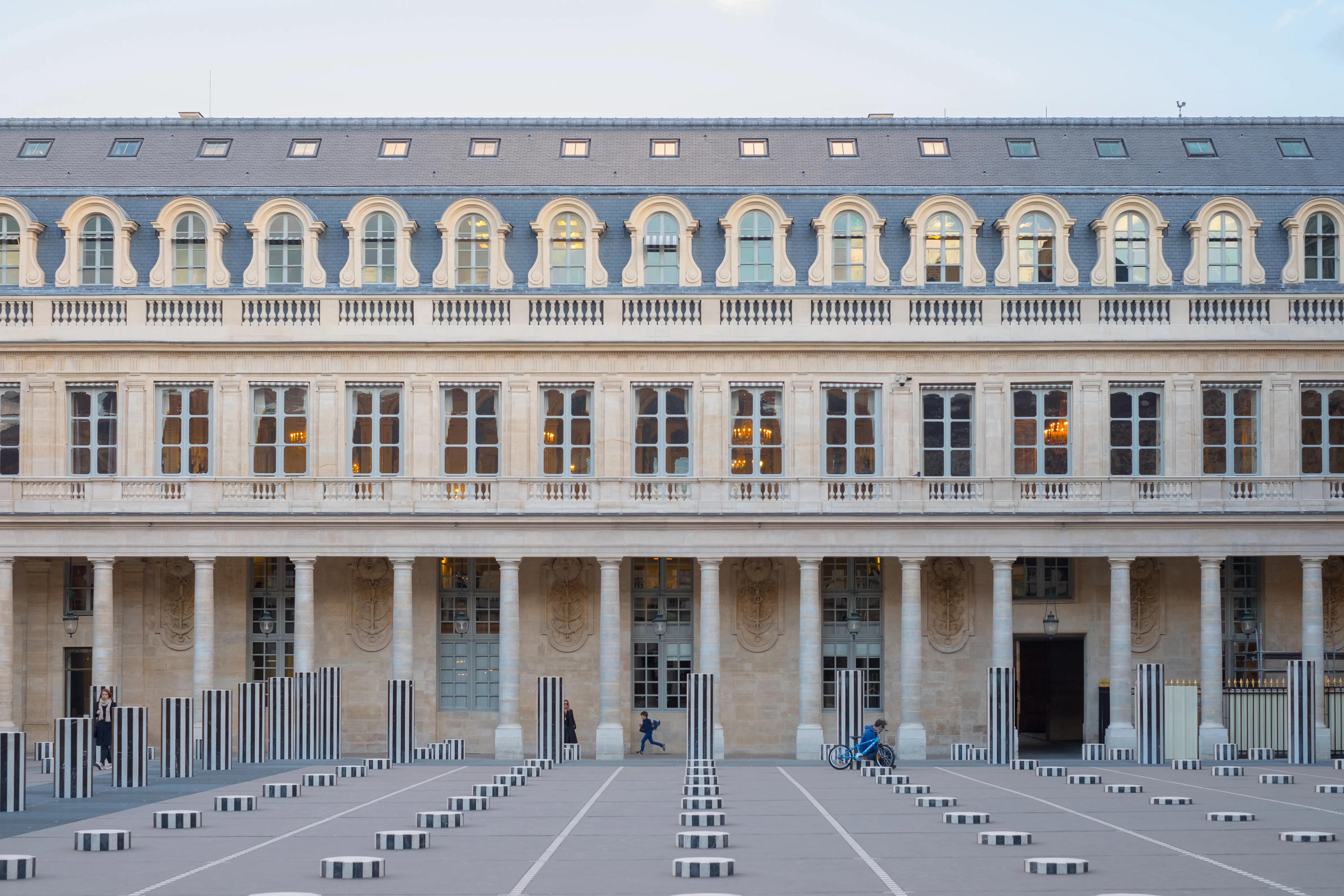 Cour du Palais-Royal avec les colonnes rayées de Buren alignées devant la façade classique à arcades