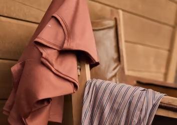Calida Fall Winter Kollektion, orangerotes Shirt und lange Hose auf einem Stuhl