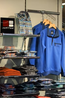 Regal mit aktueller Herrenmode im Modehaus Streb