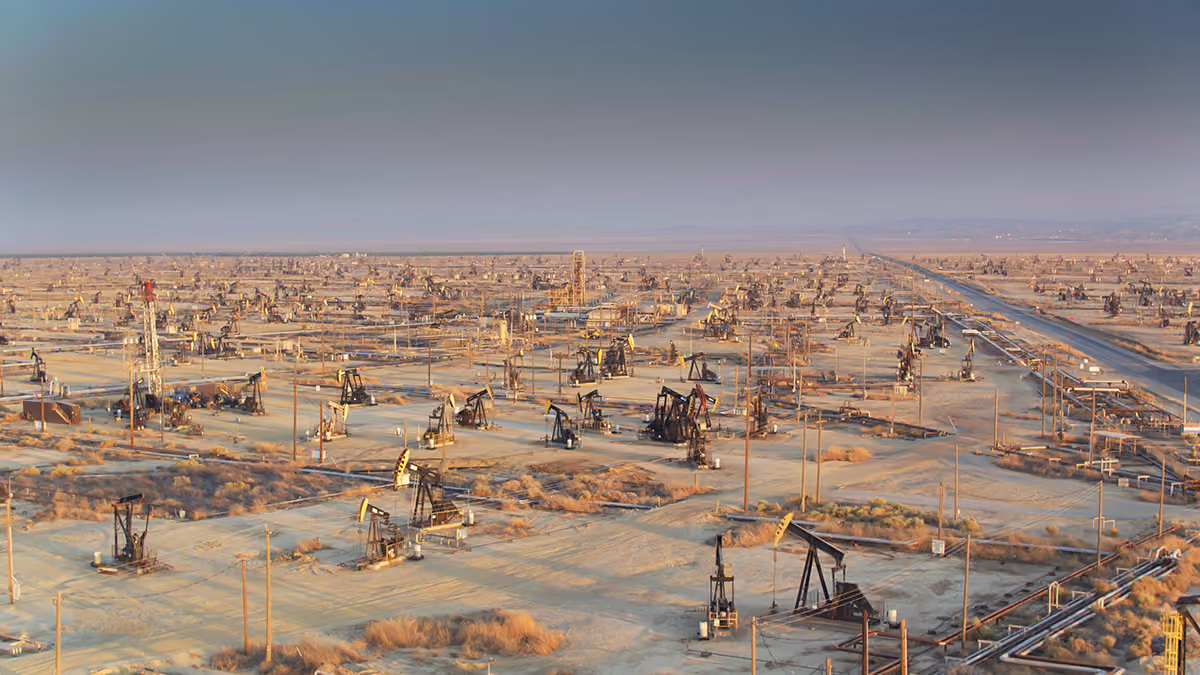 A landscape view of a Texas oil field with pumps scattering the landscape into the horizon.