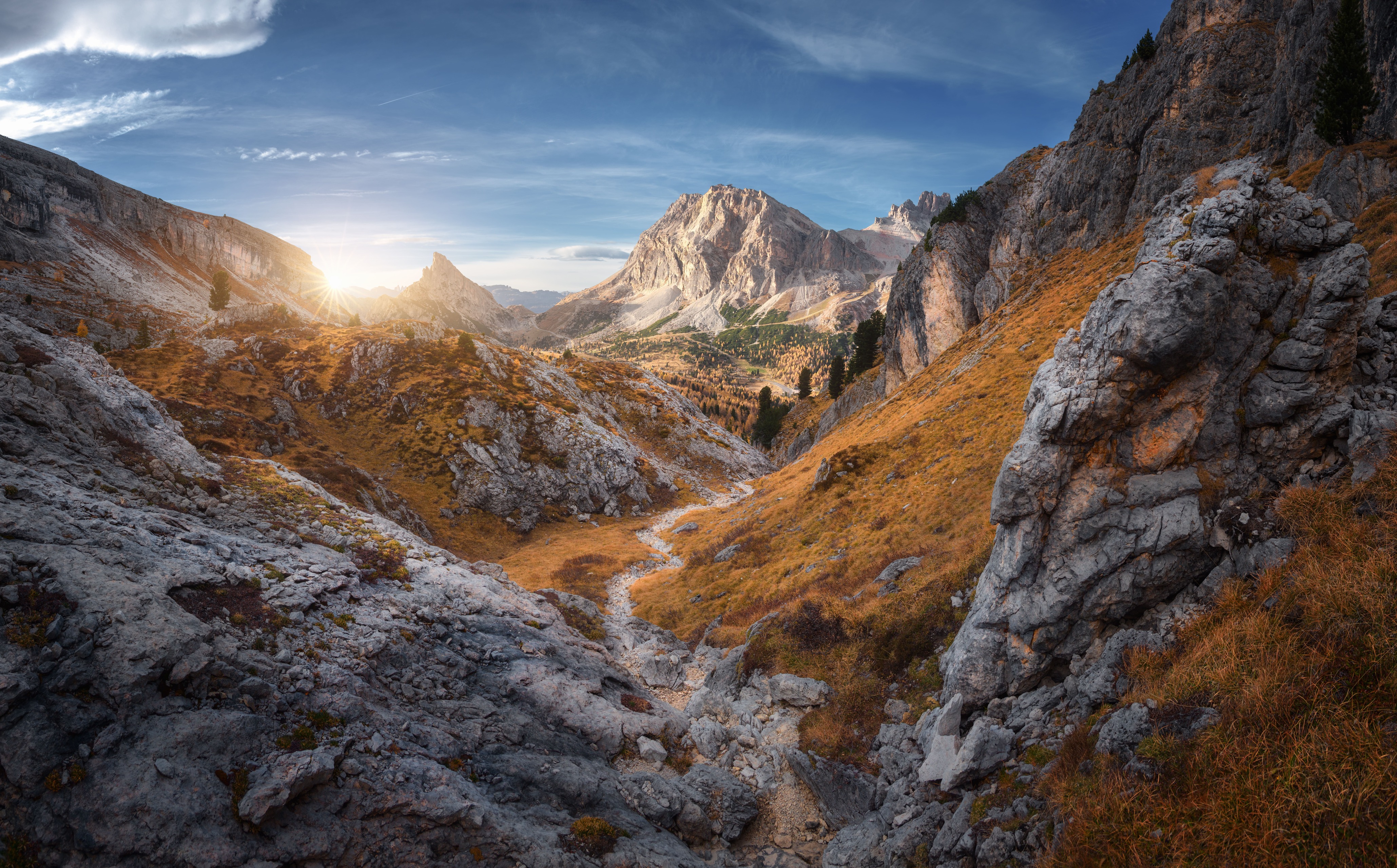 A valley view of mountains and a rock path in the centre