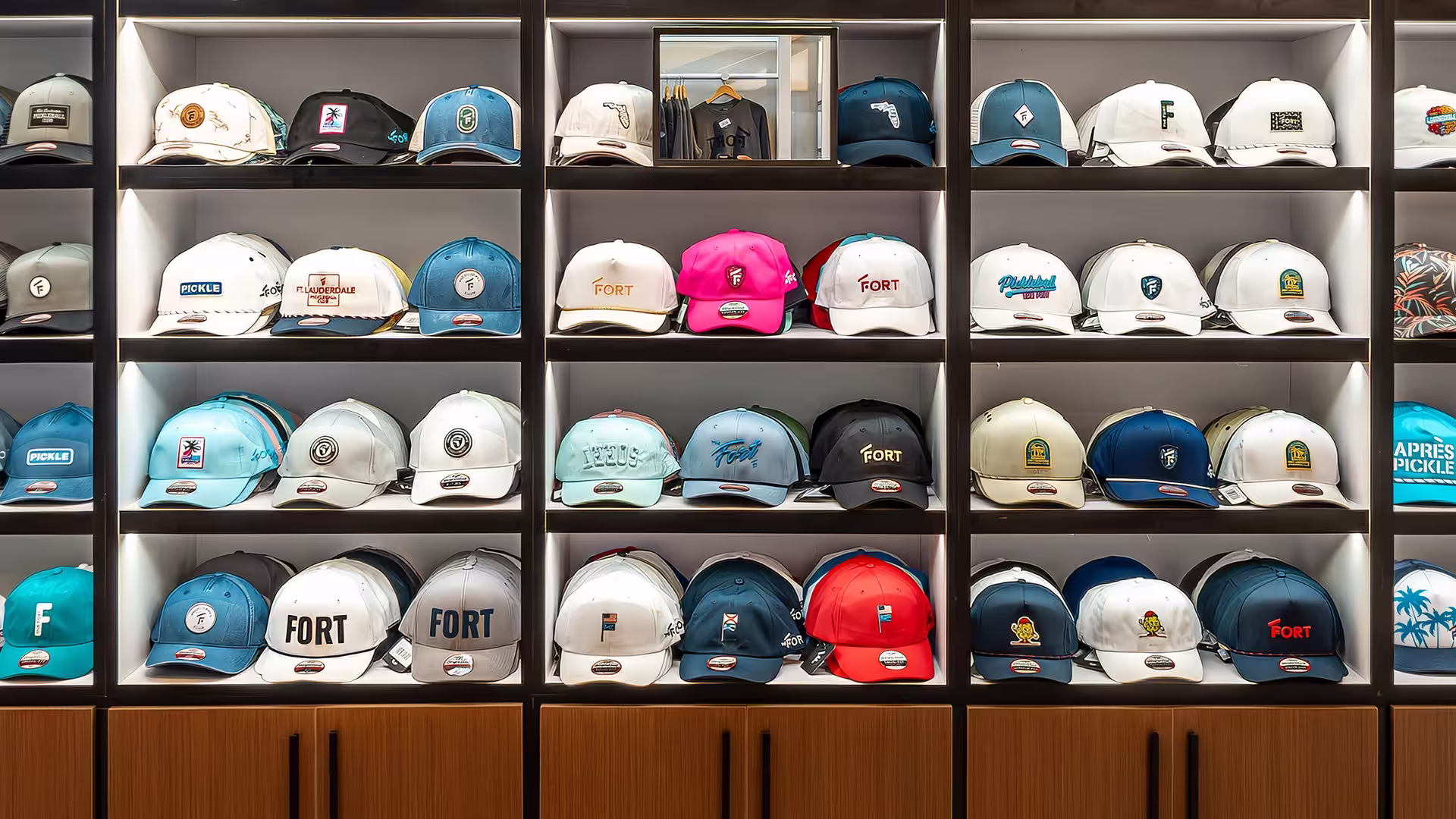 Display shelves with various colorful baseball caps, some with Fort logos and designs.