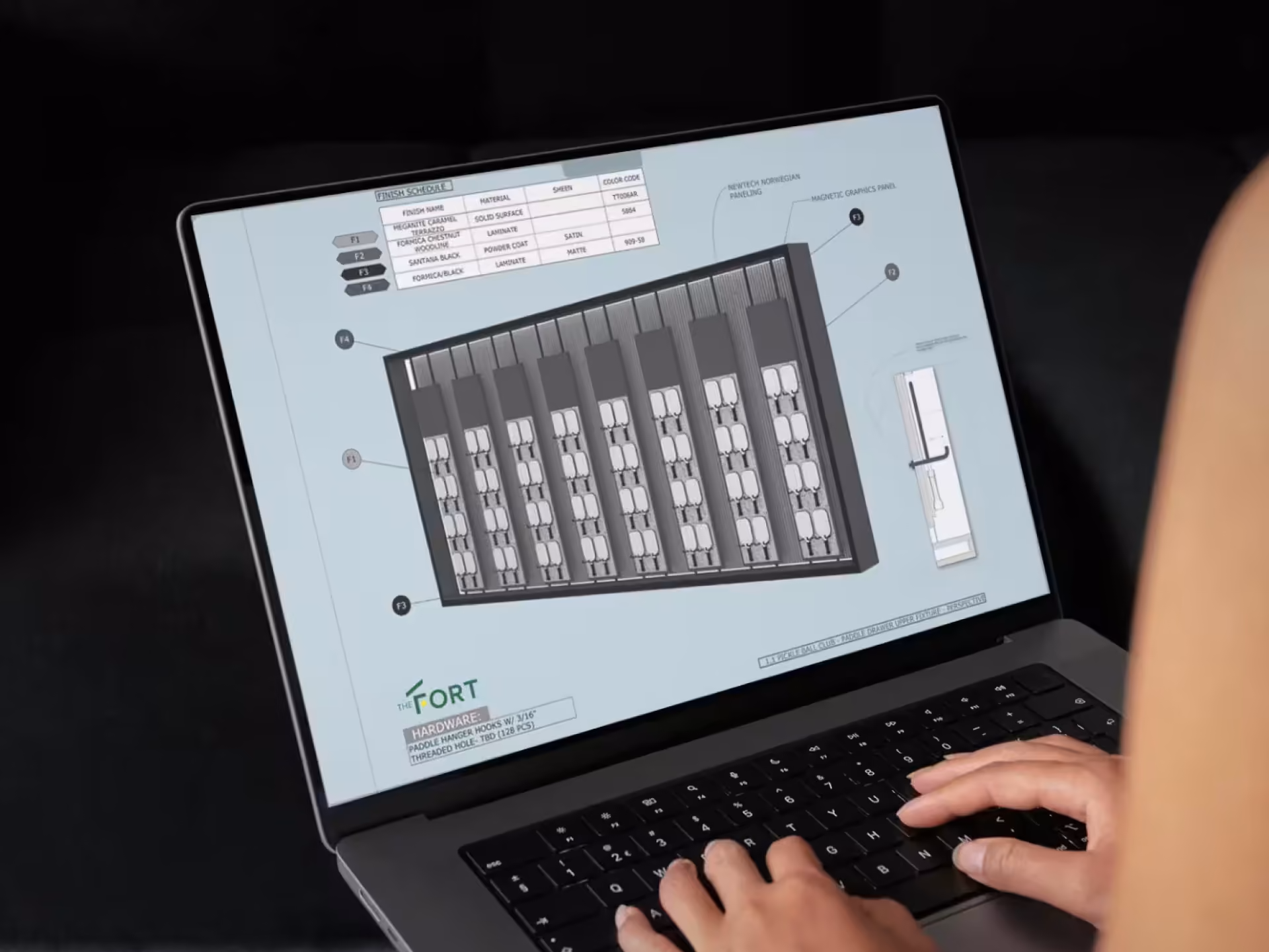 Person viewing a technical hardware schematic on a laptop screen with hands on the keyboard.