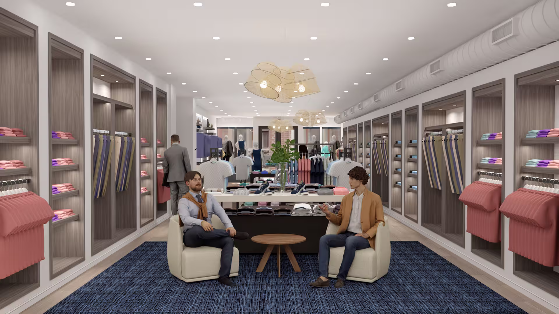 Two men sitting in chairs and talking in a modern clothing store with shelves and folded clothes.