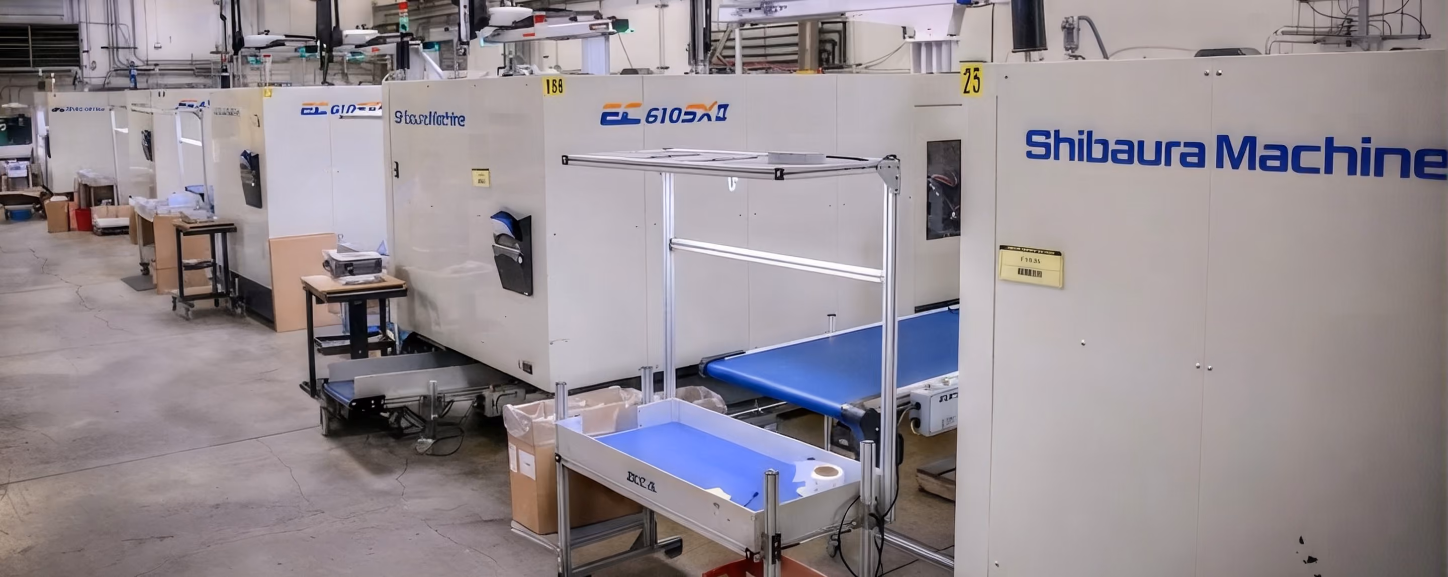 Automated gripper placing molded yellow parts onto a conveyor