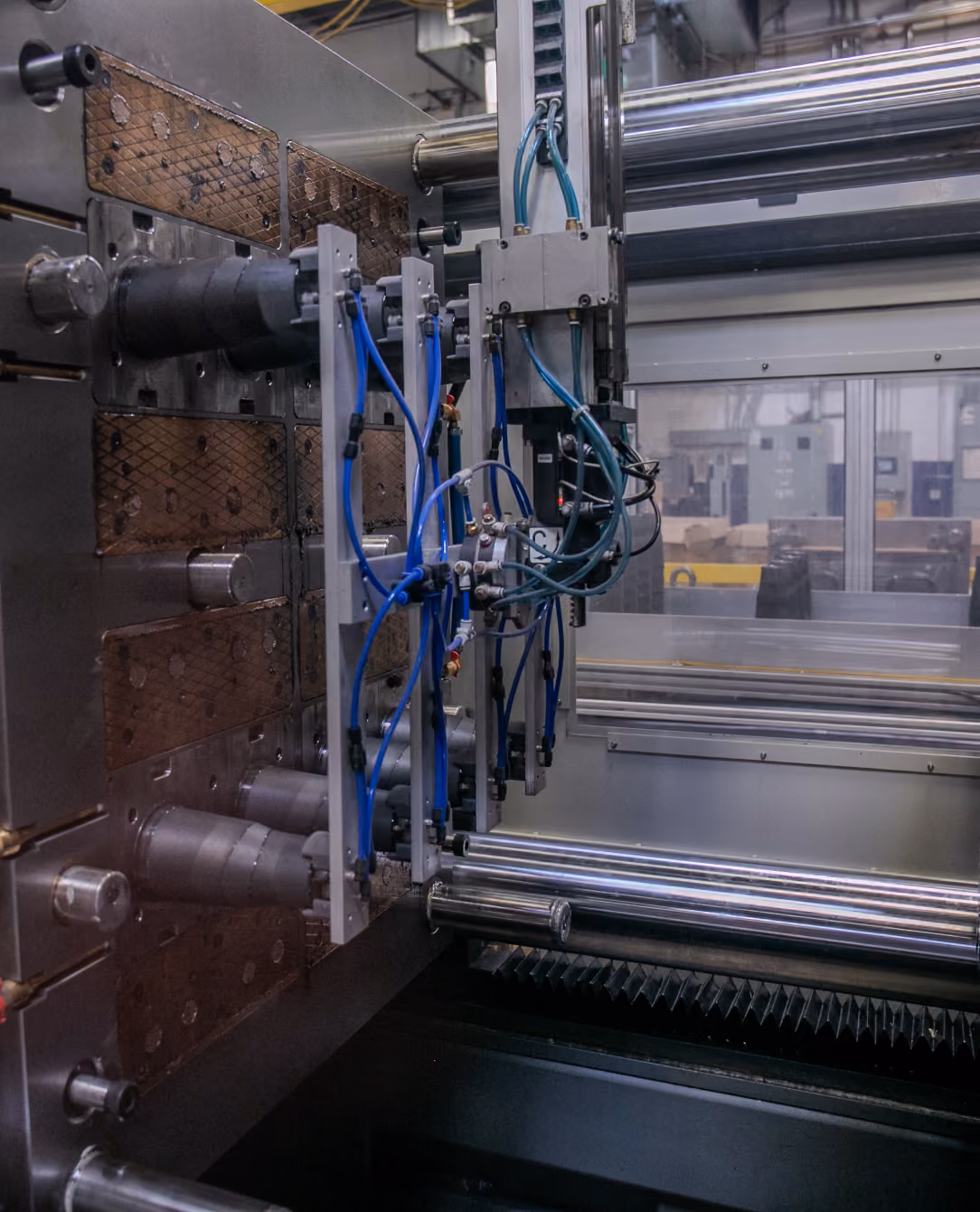 Robotic arm positioned above a precision-drilled fixture with metal pins