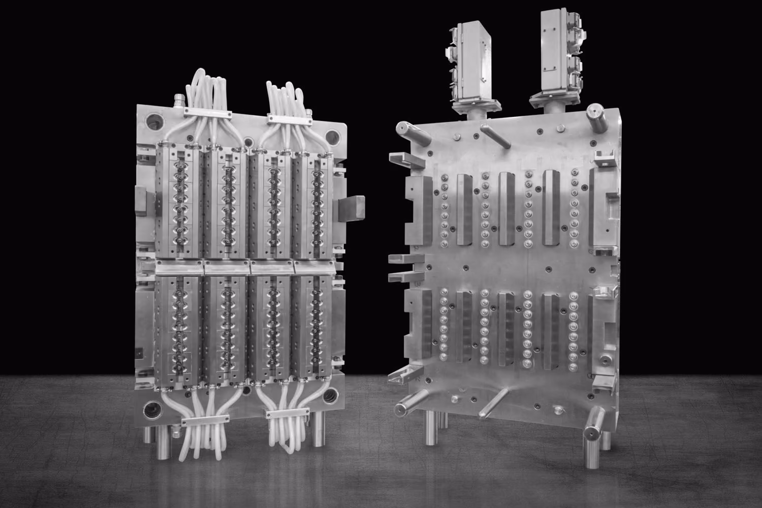 Two matched halves of an injection mold standing side by side