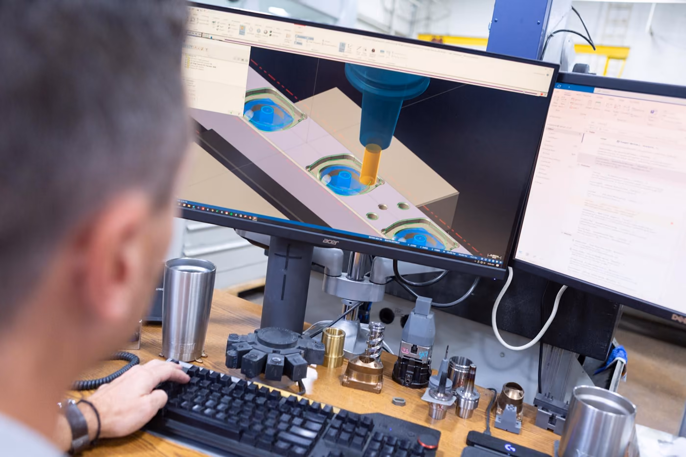 Engineer reviewing tooling data at a workstation on the plant floor