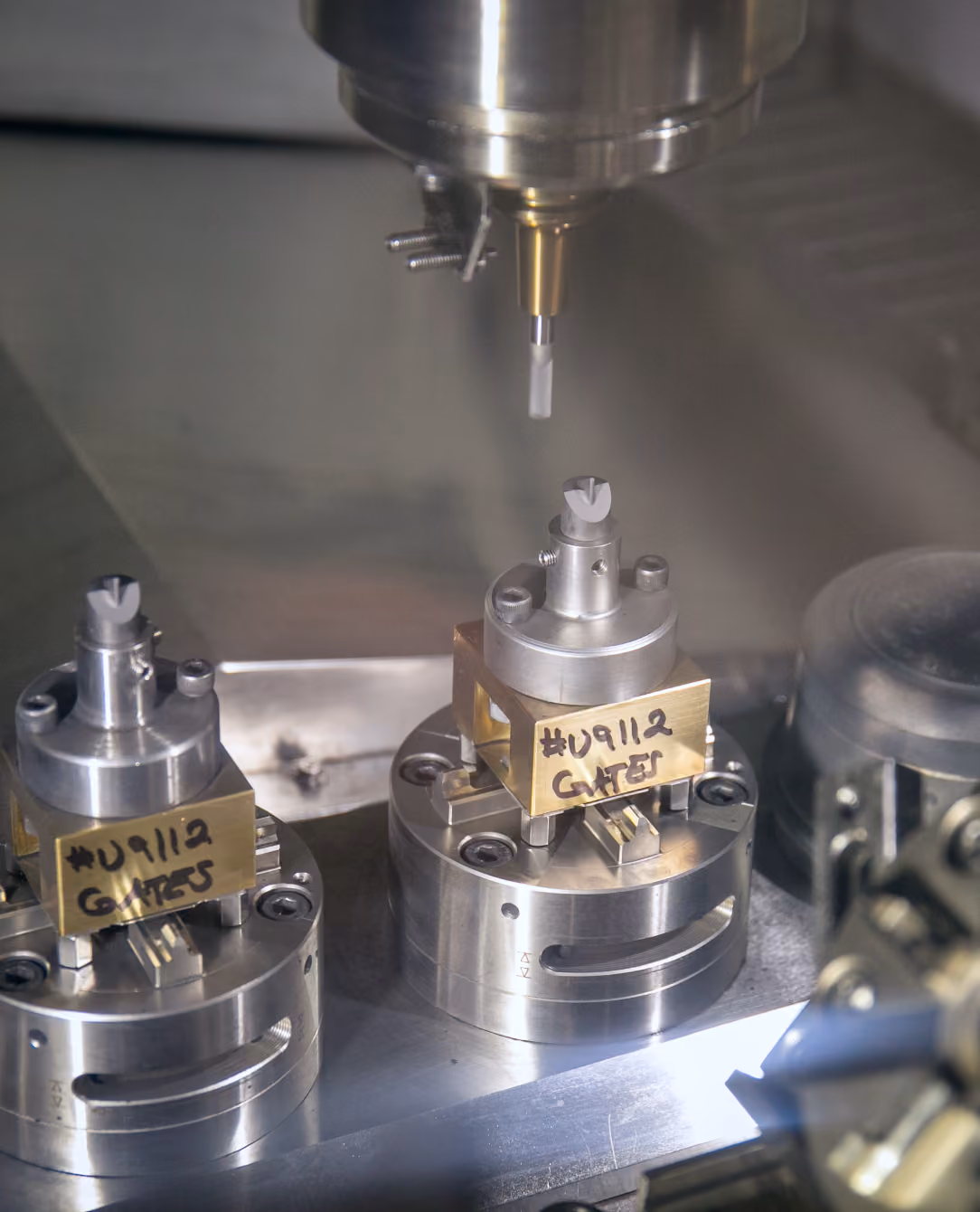 Close-up of a rotary saw cutting metal parts on an industrial grinding machine, with sparks flying