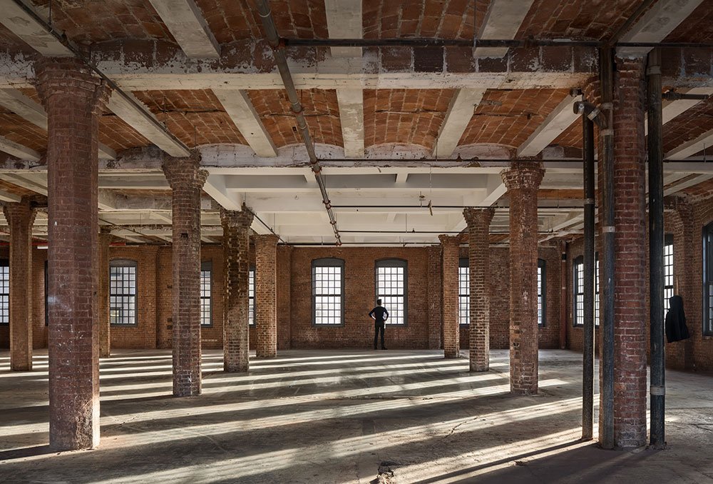 Open loft floor with restored brick columns and timber ceiling at Jay Street