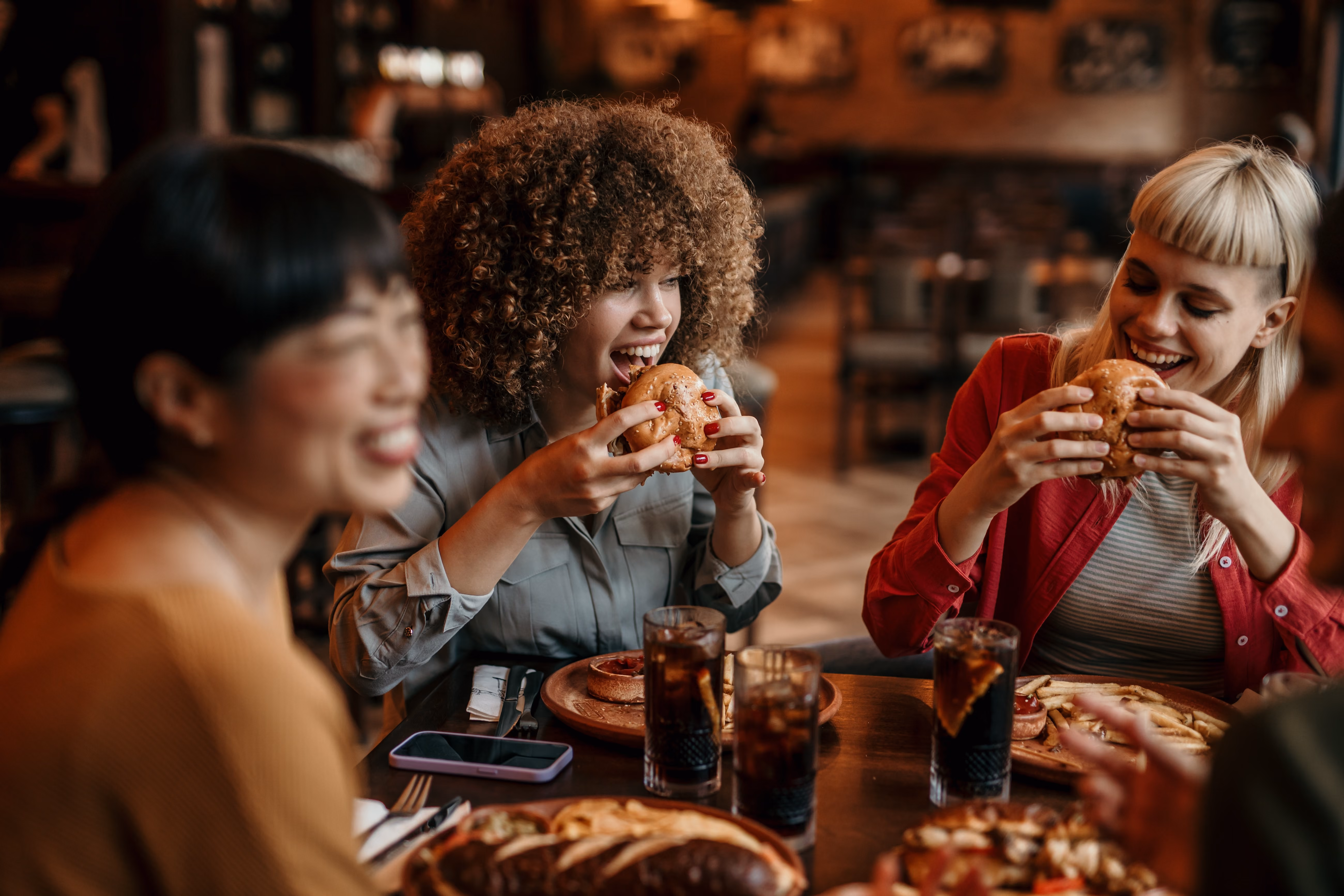 People eating cheeseburgers stock image