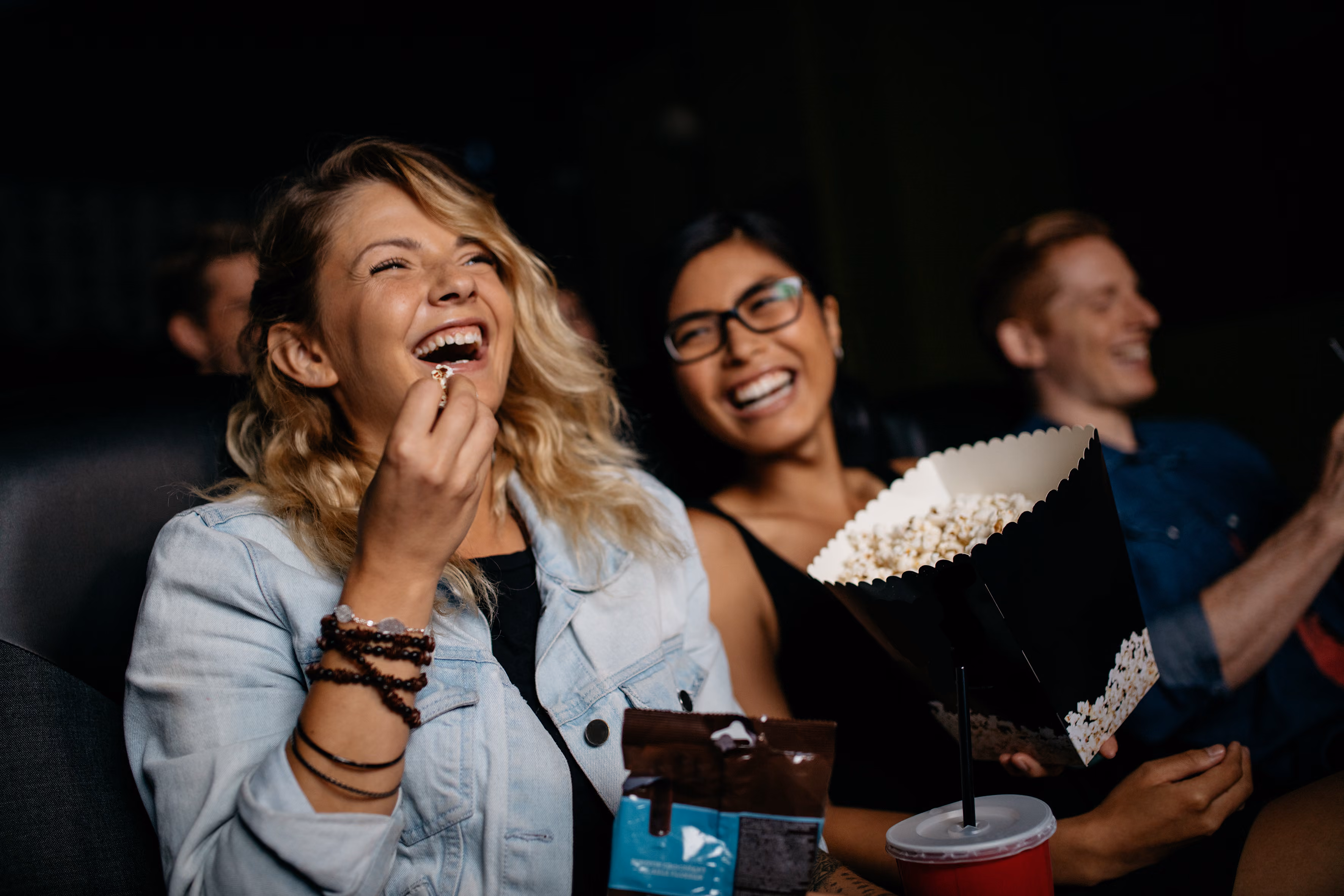 People at movie theater eating popcorn stock image
