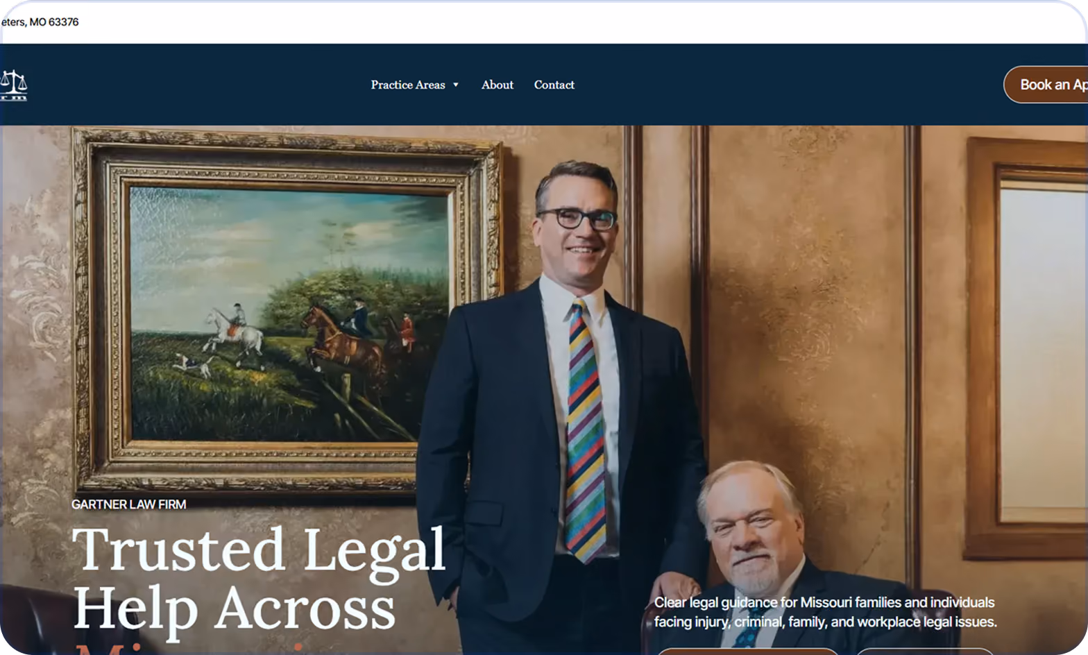 Two men in a formal office setting; one standing wearing a dark suit with a colorful striped tie and glasses, the other seated with gray hair and beard, both smiling. Behind them are framed paintings on the walls, one depicting horse riders and hunting dogs.