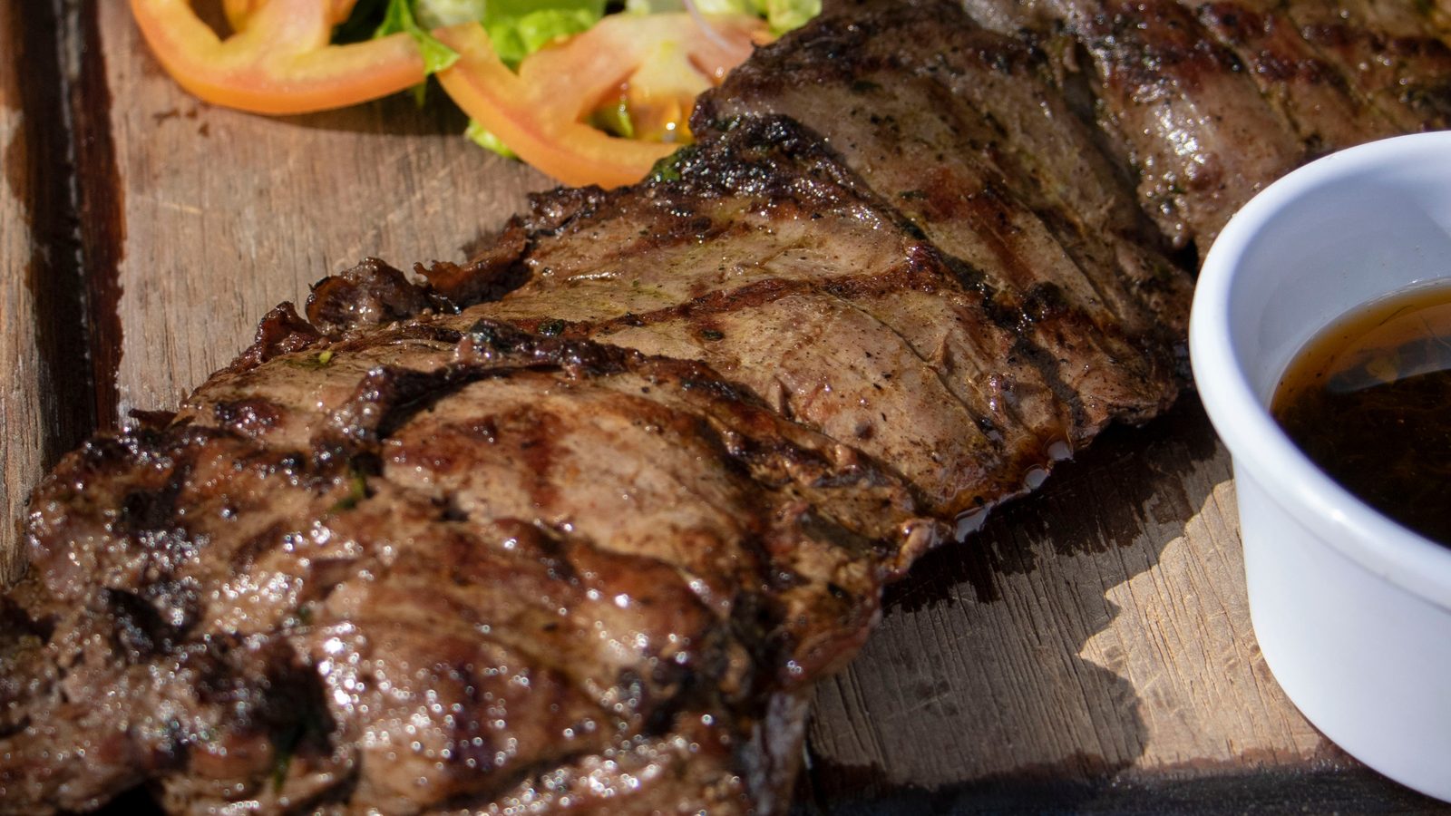 Vacío asado rebanado en tabla en Fuego Santo, parrilla en Playa del Carmen
