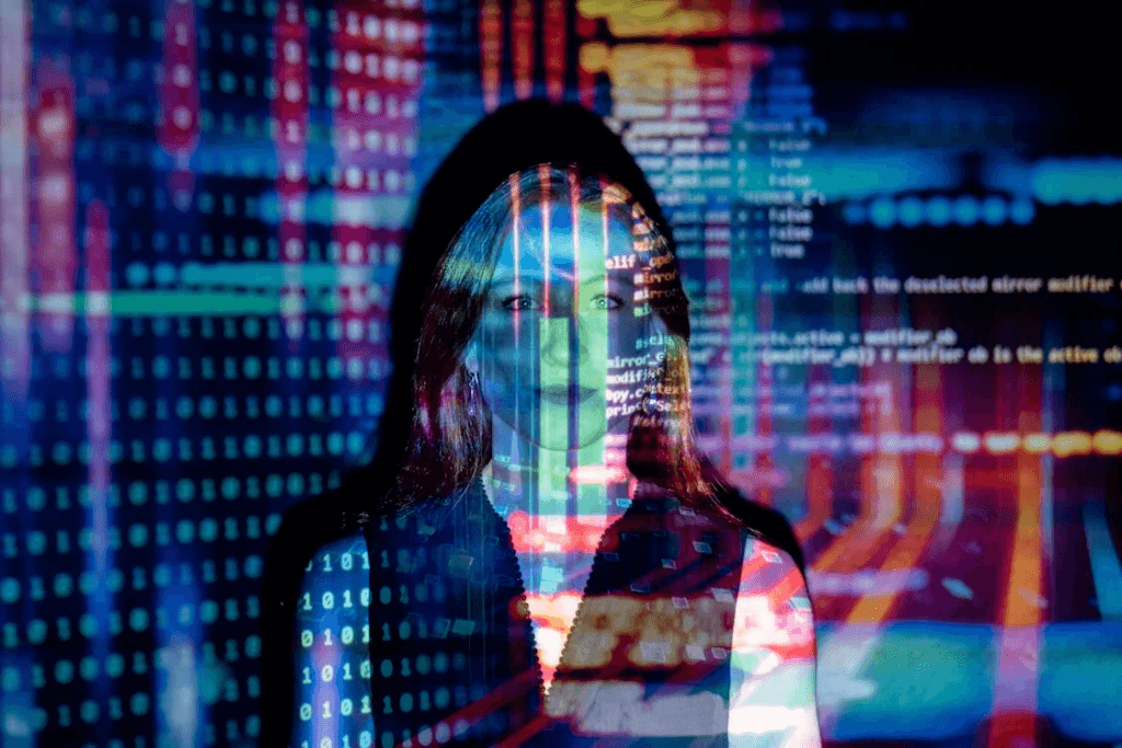 Decorative double exposure of a woman's face overlaid with projected binary digits and coloured lines of code.
