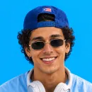 Chico con gorra viendo el celular