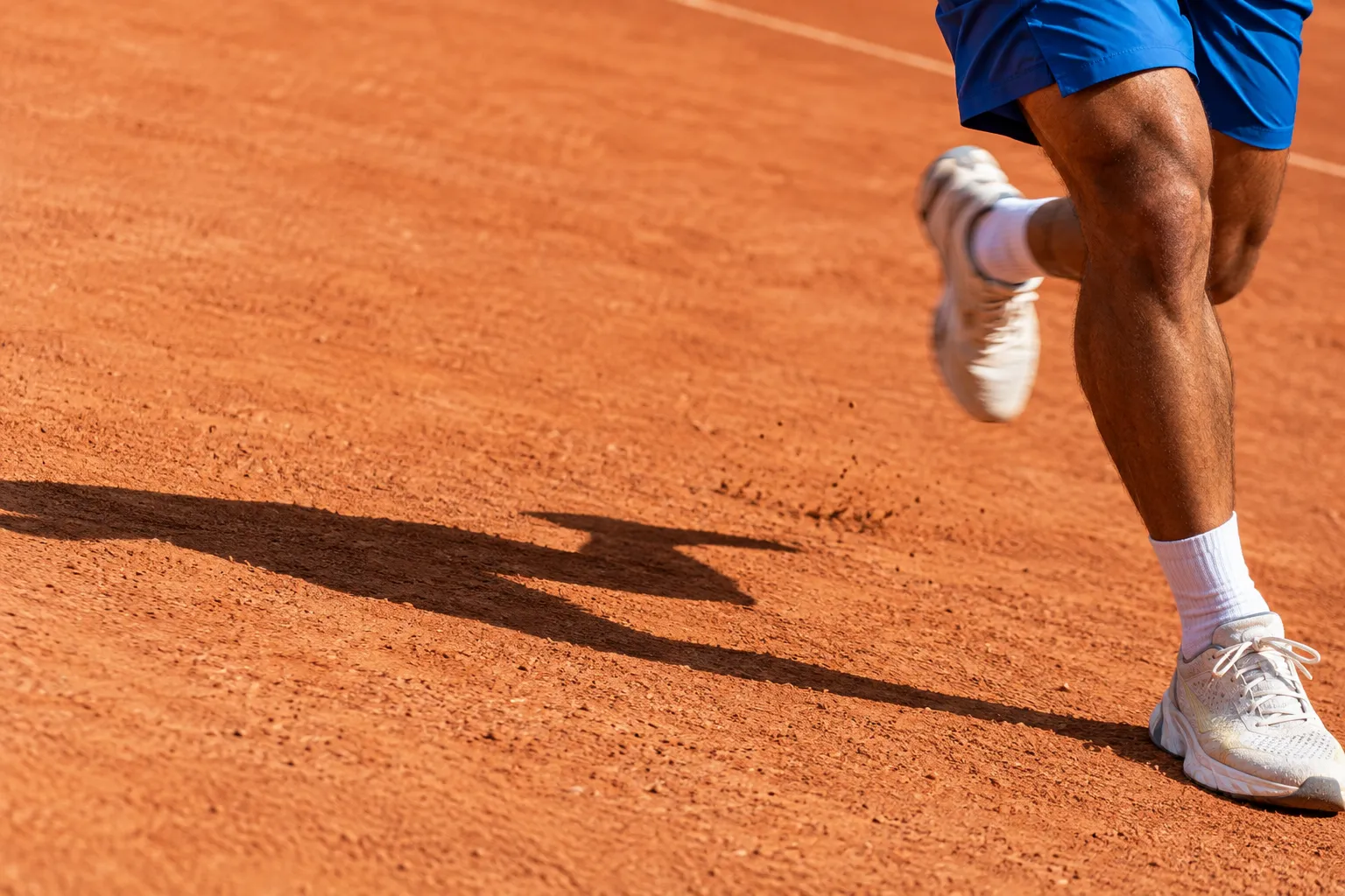 Close-up of running shoes in motion on a clay court
