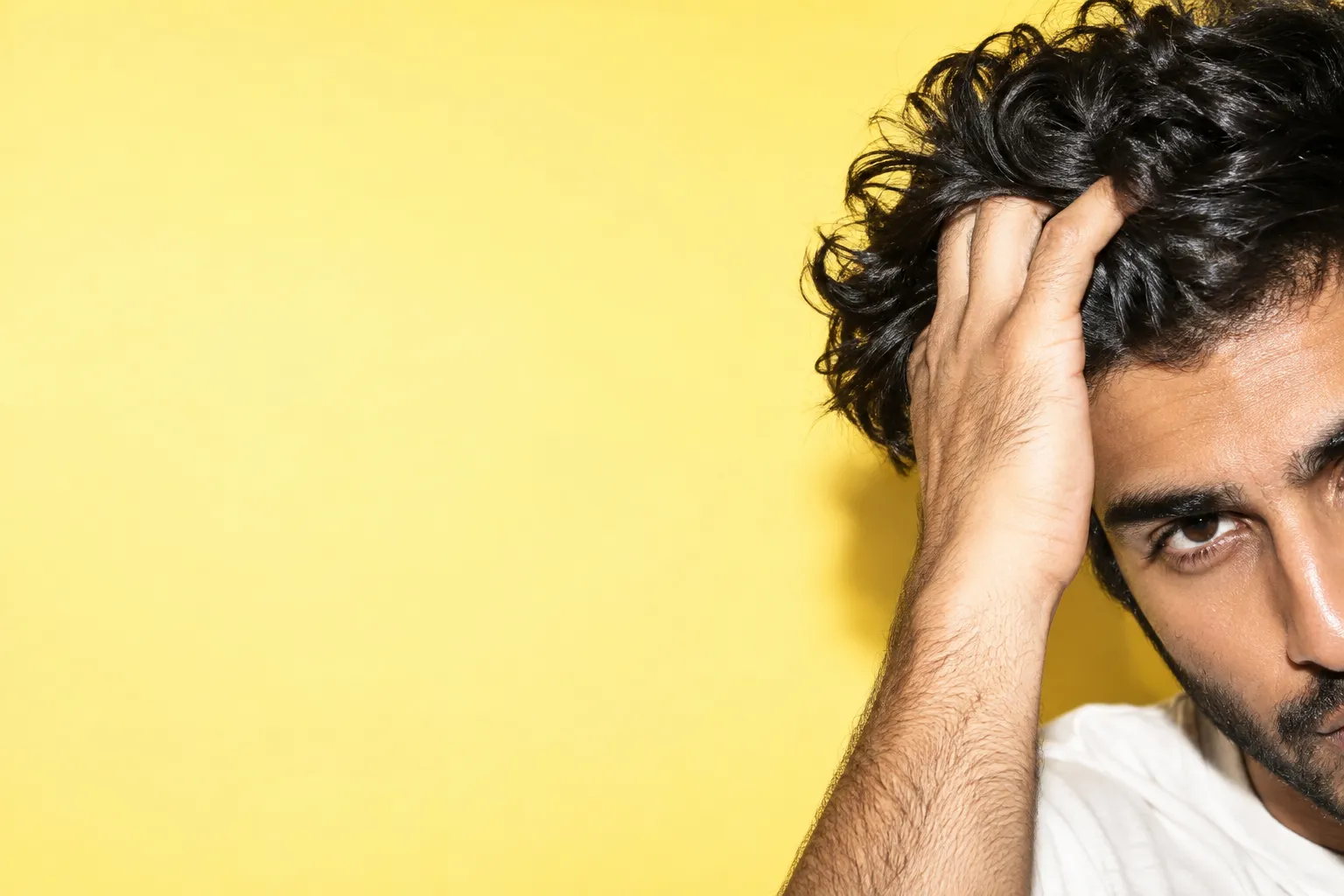 Close-up of a man's wavy hair and hand