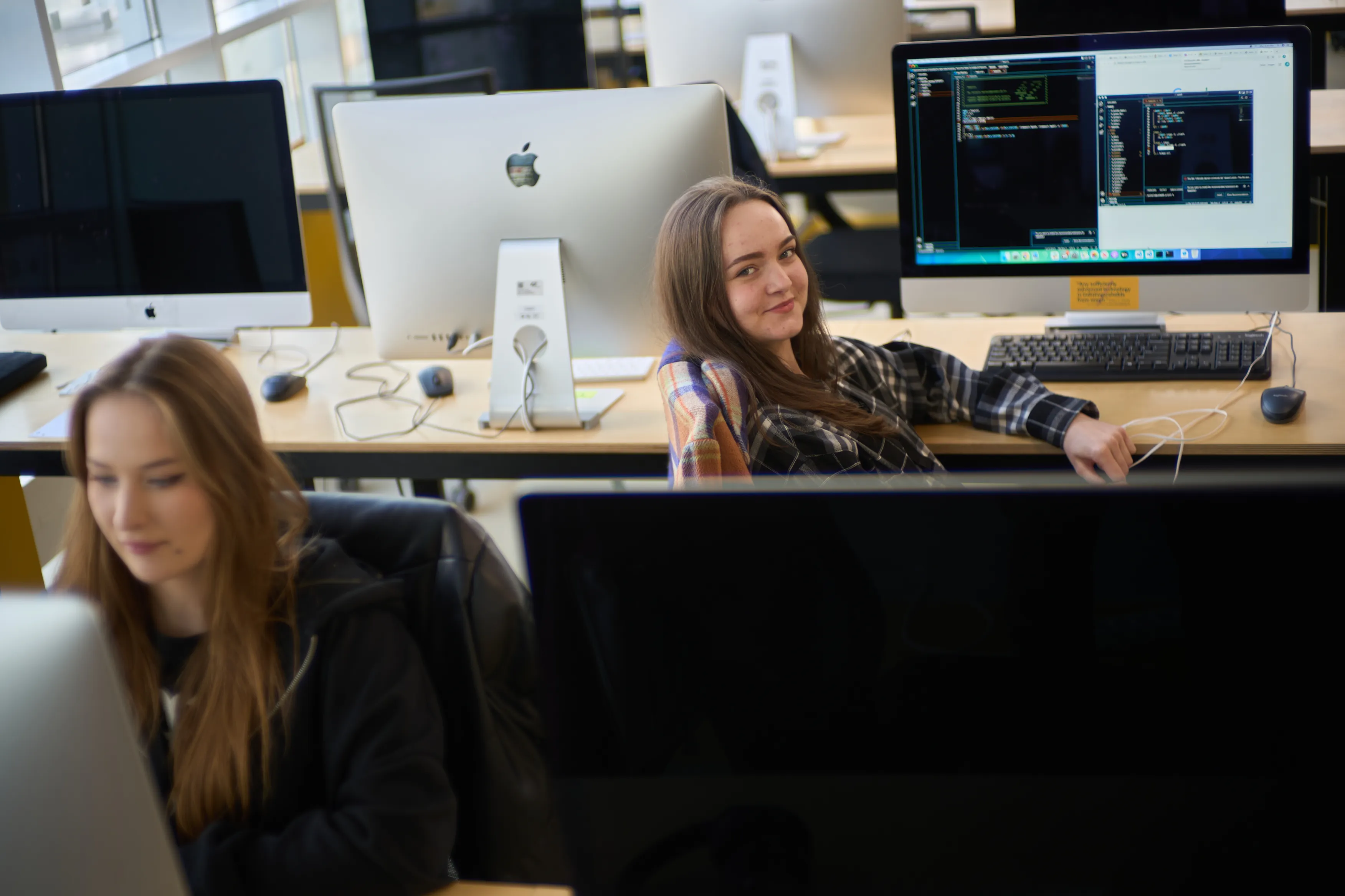 Two students coding side by side at the iMac clusters at 42 Wolfsburg