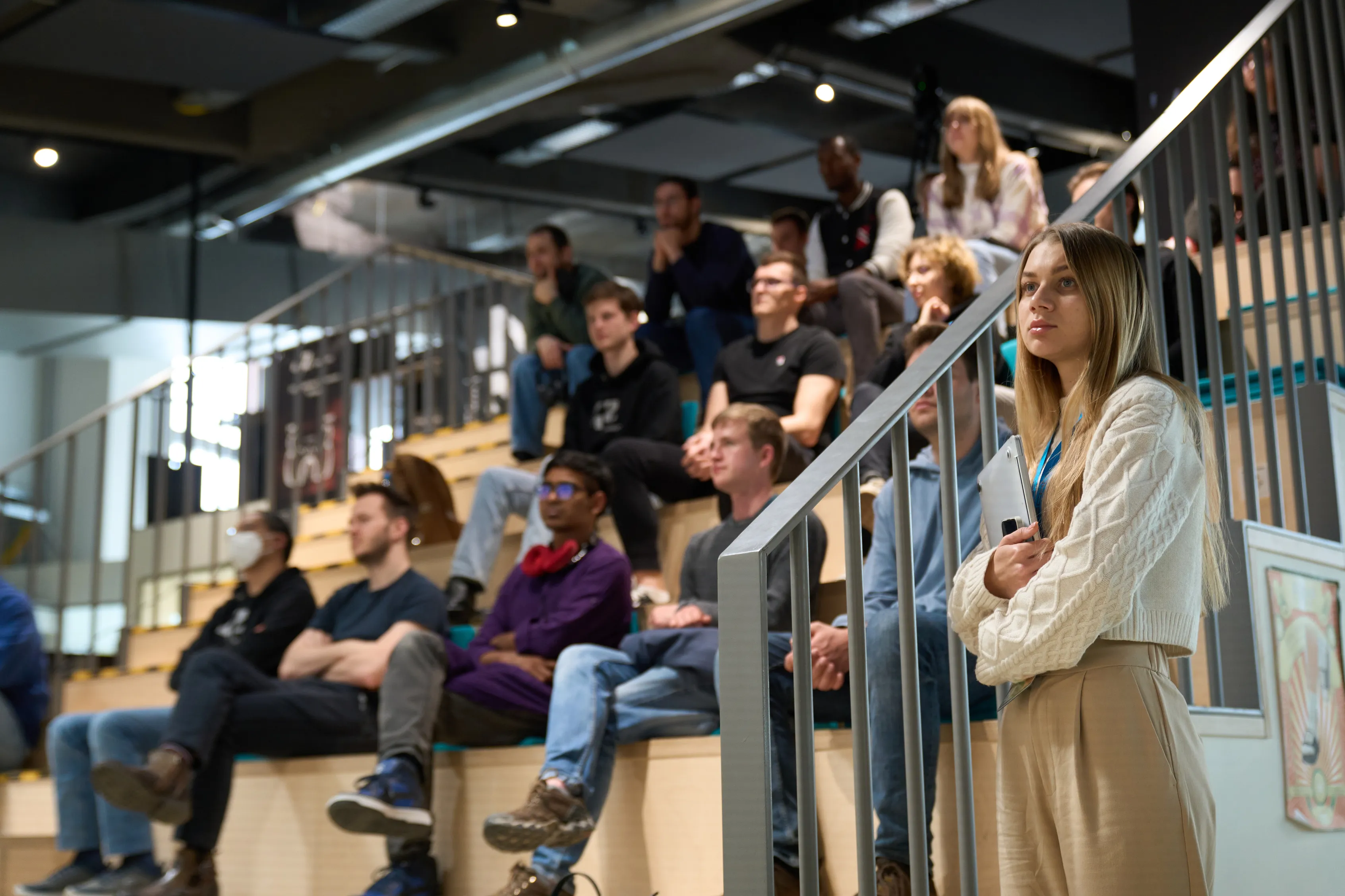 An audience watching a talk on the bleachers
