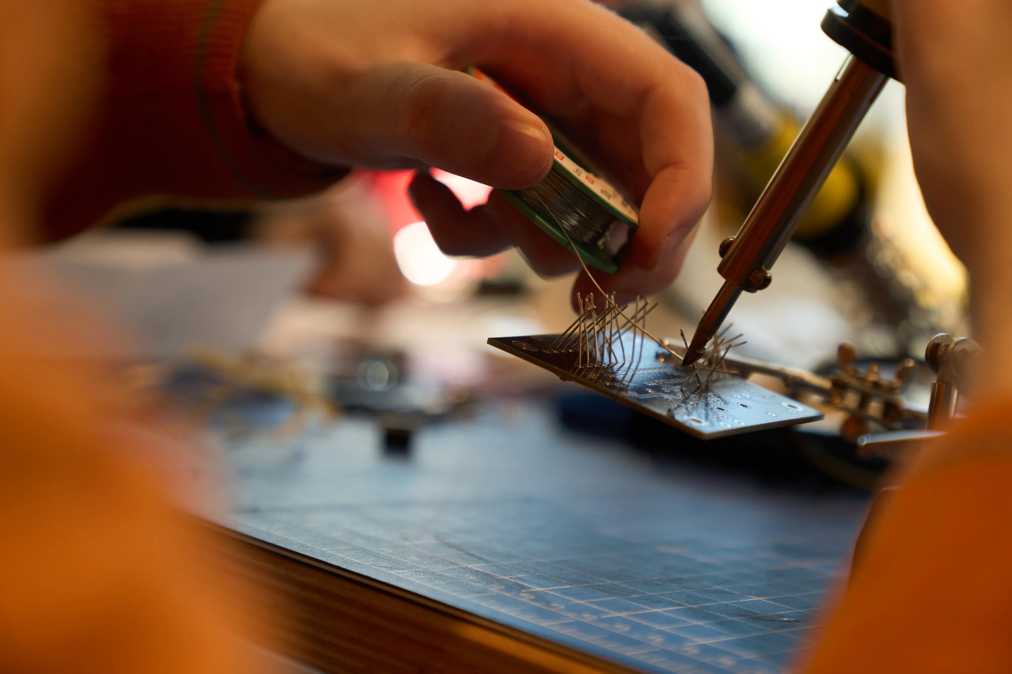A student soldering a circuit board in the FabLab