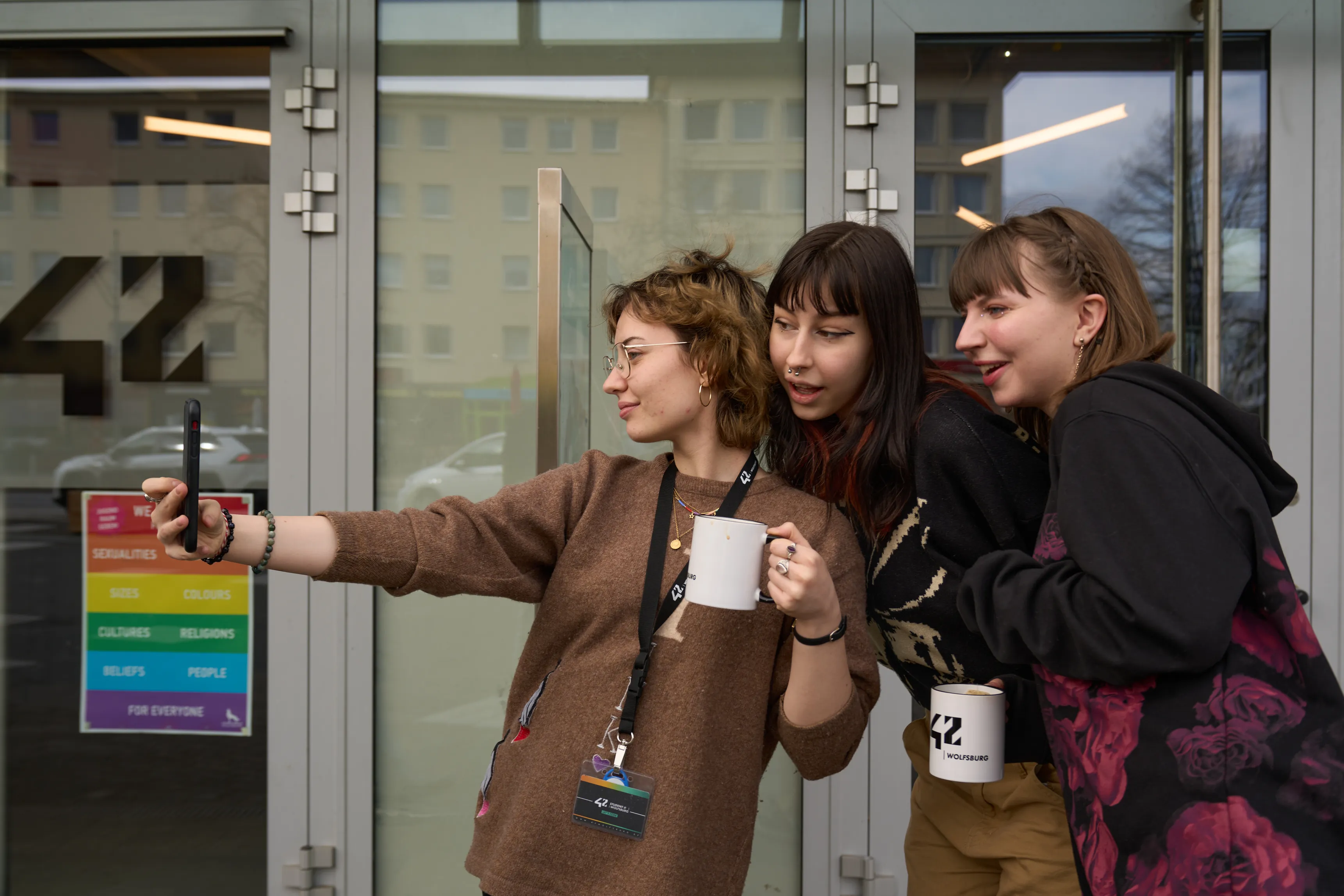 Students taking a selfie at the campus entrance